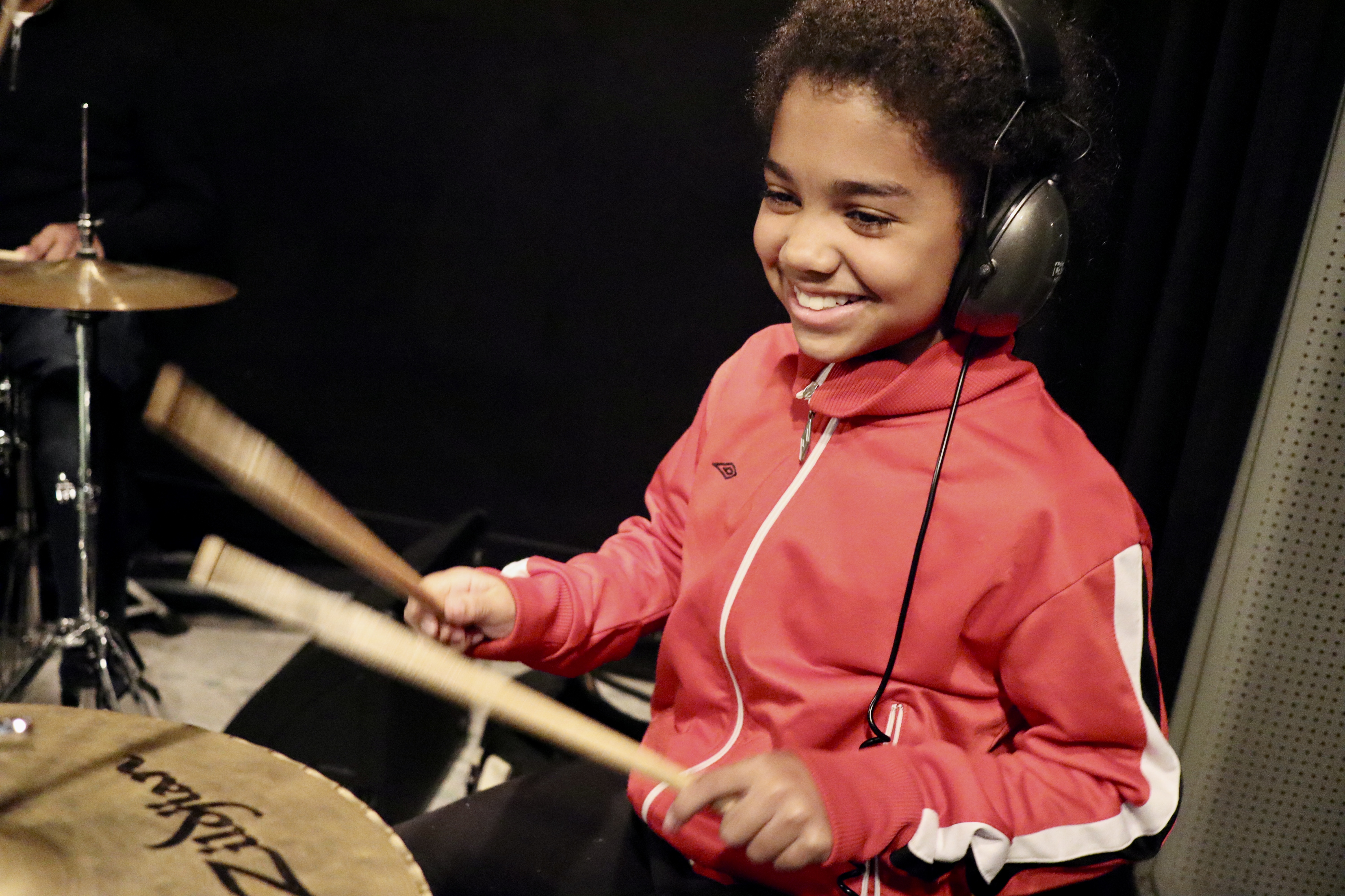 Leerling drumt enthousiast met koptelefoon op