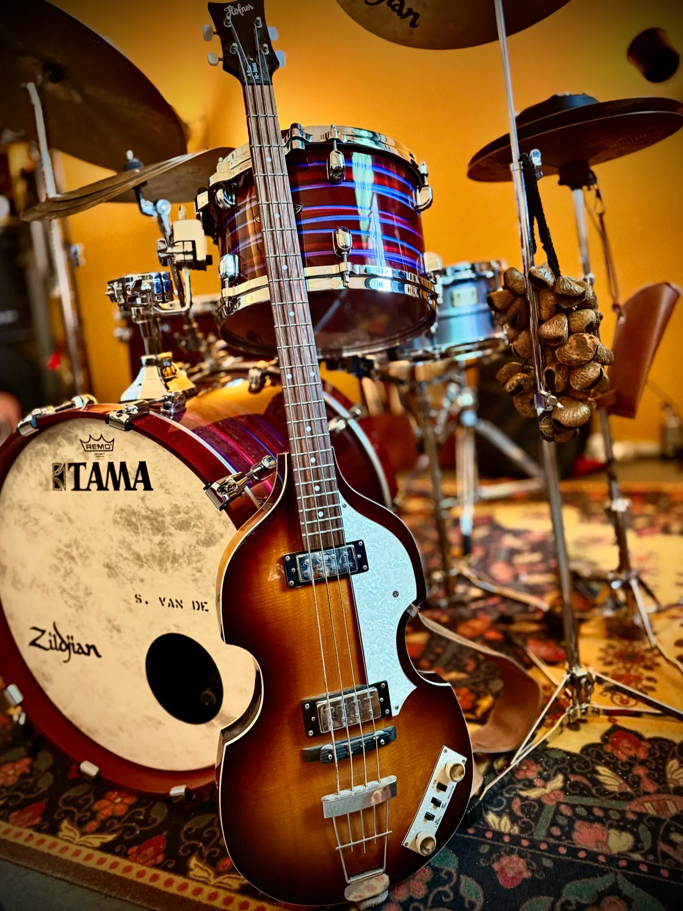 A bass guitar leaning against the drum kit in the drum studio