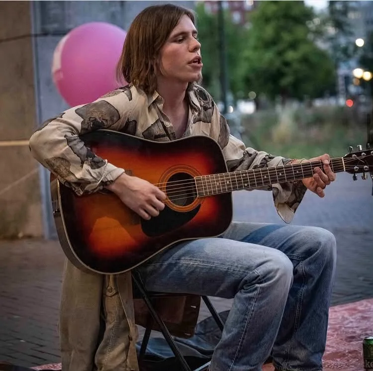 Guus van Diemen speelt akoestische gitaar en zingt